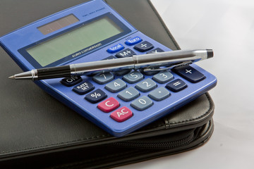 Calulator and pen on a document wallet