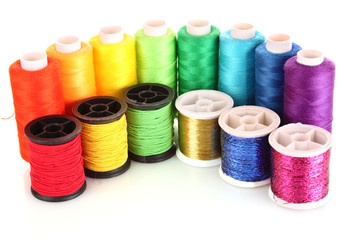 Semicircle of many-coloured bobbins of thread isolated on white