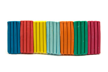 row of colorful plasticine on white background