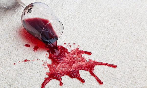 Rotweinglas verschmutzt Teppich.