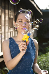 portrait of young woman blowing soap bubbles