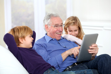 Grandfather with kids using electronic tab