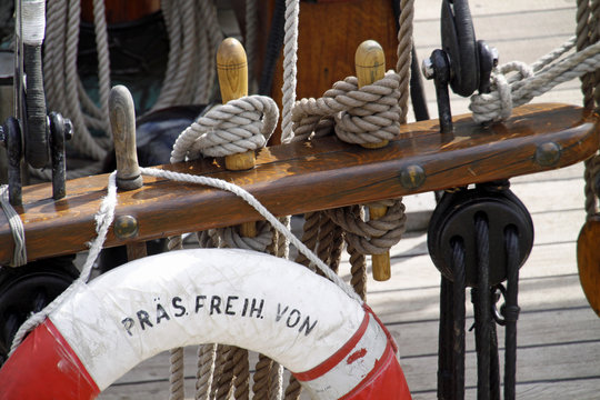 Belegnägel und Rettungsring auf einem Segelschiff
