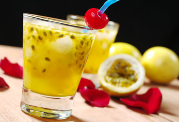 Passion-fruit juice with drinking straw and a cherry