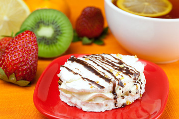 lemon tea, kiwi,cake and strawberries lying on the orange fabric