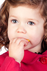 Adorable baby girl eating sweets