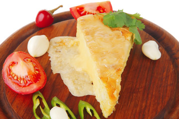 Fototapeta na wymiar cheese pie on wooden dish with tomatoes and pepper