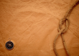 compass and rope on old yellow paper