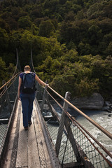 Fototapeta premium Woman passing a suspension bridge