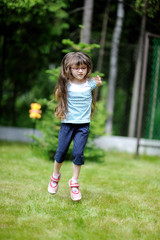 Fototapeta premium Adorable active little girl plays on backyard in spring