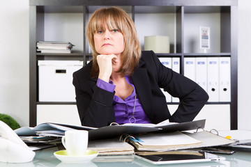 gestresste frau im büro am schreibtisch