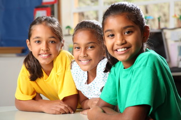 Three young primary school girls sitting in class