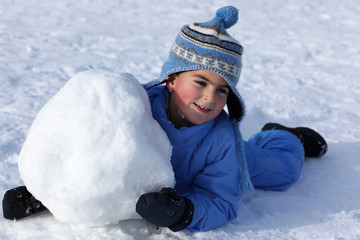 bambino sorridente con grossa palla di neve
