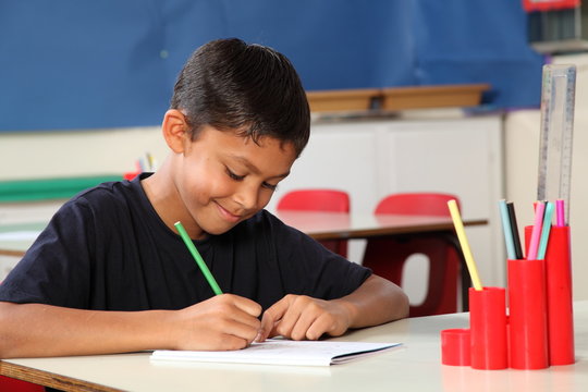 Young School Boy 10 Writing At His Classroom Desk