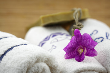 Obraz na płótnie Canvas Salon wystrój: ręczniki, mydło i orchidea na tle bambusa