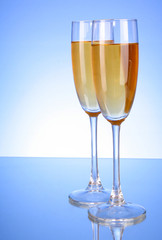 Glass with champagne on blue background