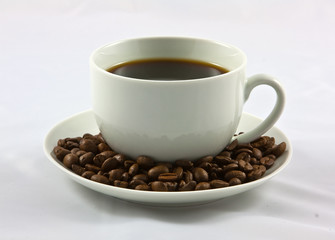 coffee cup on a suacer of beans