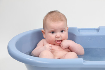 Three month old baby taking a bath