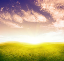 Green grass hills under colour cloud sky.