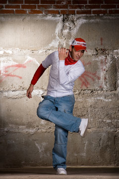 Hip Hop Boy Dancing In Modern Style Over Grey Brick Wall