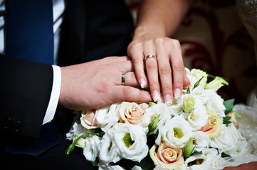 Obraz na płótnie Canvas Hands with wedding gold rings happy newlyweds