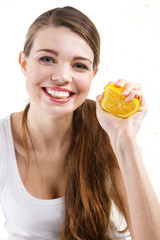 Attractive young woman squeezing and orange