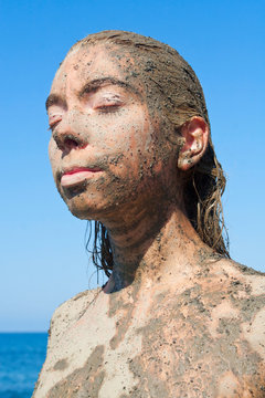 Young beautiful woman getting a body mud therapy