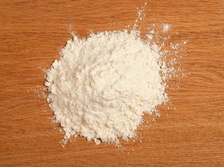 Fototapeta na wymiar Wheat flour heap on a wooden background