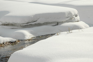 Small curved stream on snow