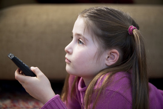 m&auml;dchen mit Fernbedienung beim fernsehen