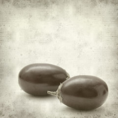 textured old paper background with small round aubergines