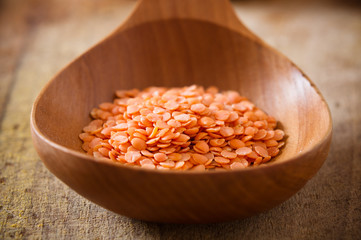 Red lentils in wooden spoon