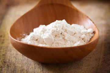 Fototapeta na wymiar Pile z białej mąki z drewnianą łyżką