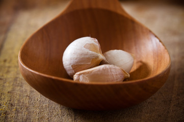 Cloves of garlic in the wooden spoon