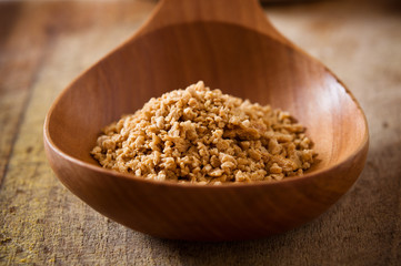 Pile of soy granules in wooden spoon