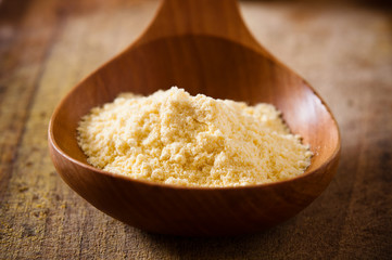 Pile of corn flour with wooden spoon