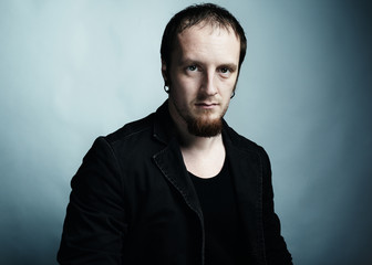 Artistic dark portrait of the young beautiful man with dark eyes