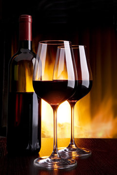 wine by the glass against the fireplace with fire
