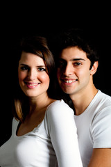 Young smiling couple on black background