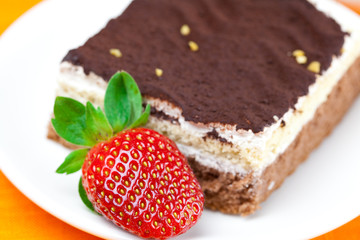 cake and strawberries lying on the orange fabric