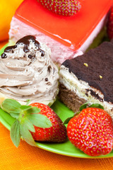 cake and strawberries lying on the orange fabric