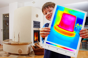 boy showing thermal imaging of a warm masonry stove