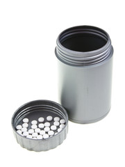 white tablets on lid of gray medicine bottle