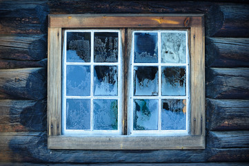 Window of a traditional Norwegian hut with beautiful frostwork
