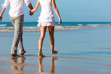 Paar beim Spaziergang  am Strand im Urlaub