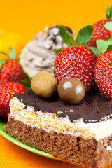 cake, chocolates and the strawberries on the orange fabric