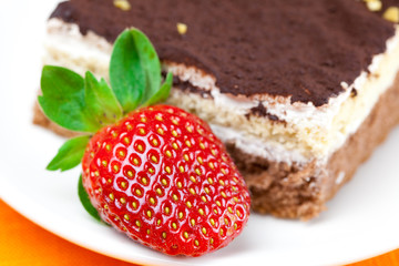 cake and strawberries lying on the orange fabric