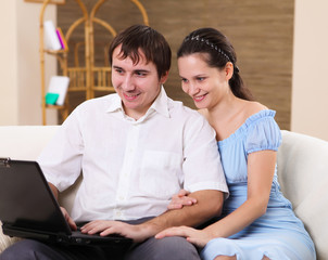 young family at home with a laptop