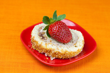cake and strawberries lying on the orange fabric
