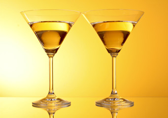 two glasses of martini on a yellow background
